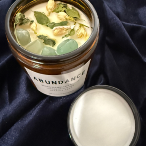 Candle for abundance with herbs and crystals